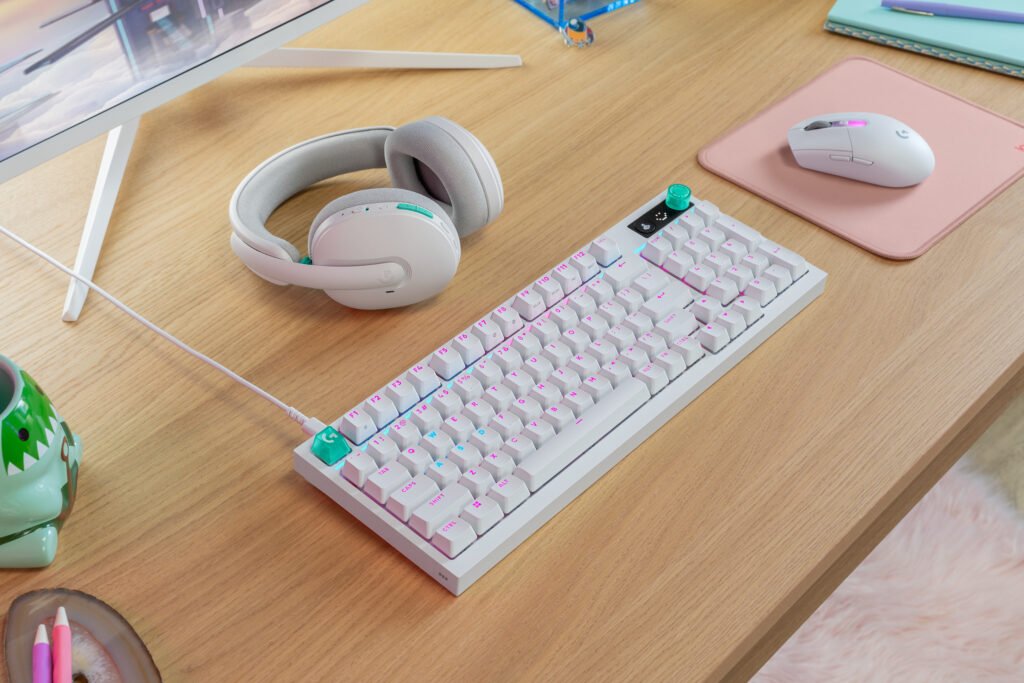 Pastel desk setup with white over-ear headphones, a white keyboard with pink keys, and a pink mouse on a pink pad. G316 X 98 G305 X Superlight G325 ENVR White Desk Setup Alt