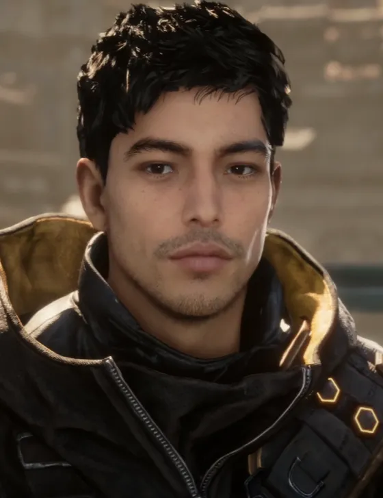 Young man with short black hair wearing a dark jacket with a tan hood, outdoors, looking at the camera. GwbtfgWXEAIYHaS