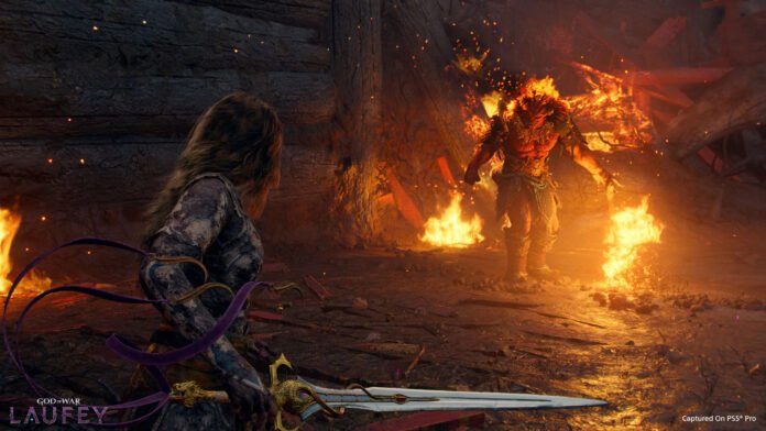 God of War: Laufey – עוד ספינאוף לאוסף Warrior kneels in a lava-lit cavern, facing a flaming demon amid sparks and rubble.