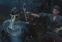 Two samurai duel at night as one man slashes with a sword, sparks flying and blood on their robes, a wooden fence behind them.