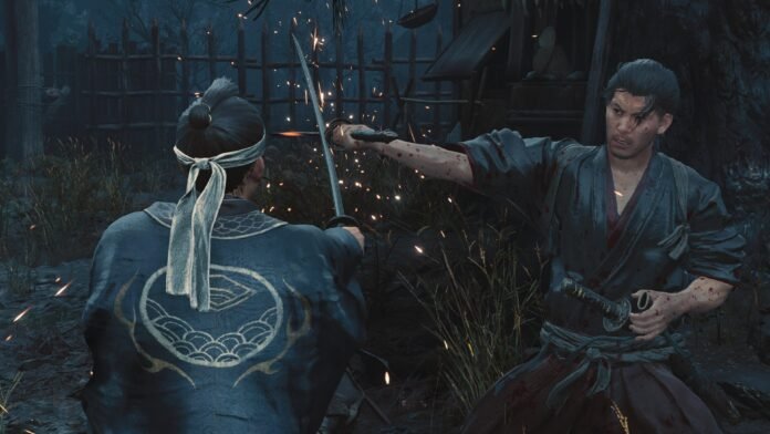Two samurai duel at night as one man slashes with a sword, sparks flying and blood on their robes, a wooden fence behind them.