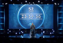 Blizzcon 2026: כל ההכרזות הגדולות של בליזארד במקום אחד Stage featuring a large circular countdown clock showing 52 days and 23:59:56, with a person in elaborate blue costume center stage and blue lighting surrounding the World of Warcraft event backdrop.