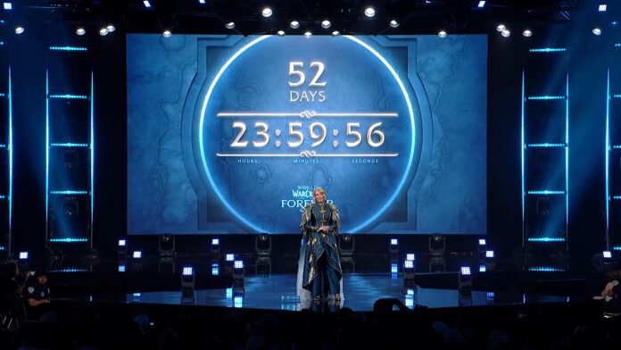 Stage featuring a large circular countdown clock showing 52 days and 23:59:56, with a person in elaborate blue costume center stage and blue lighting surrounding the World of Warcraft event backdrop.